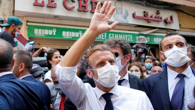 Presiden Prancis Emmanuel Macron melambaikan tangan saat mengunjungi lokasi ledakan di Beirut, Lebanon, Kamis (6/8). Foto: Thibault Camus/Pool via REUTERS