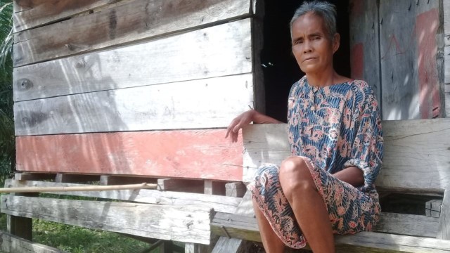 Seorang perempuan tua dari komunitas adat Kubu Lalan atau Suku Anak Dalam Yusnani berada di rumahnya di tepi Desa Tanjung Lebar, Kecamatan Bahar Selatan, Kabupaten Muaro Jambi. (Foto: Suwandi)