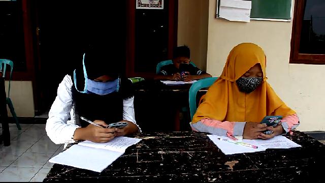 Sejumlah siswa di Kabupaten Temanggung terpaksa belajar di Balai Desa Keblukan, Kecamatan Kaloran, karena sulit mendapatkan sinyal internet, Jumat (7/8/2020). Foto: ari/Tugu Jogja.