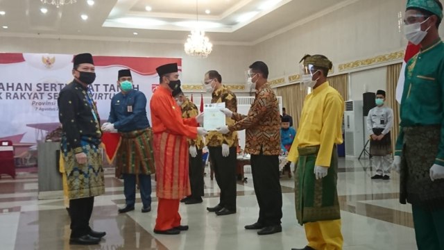 GUBERNUR Riau, Syamsuar, serahkan sertifikat secara simbolis, Jumat (7/8/2020), di Gedung Daerah Provinsi Riau. 