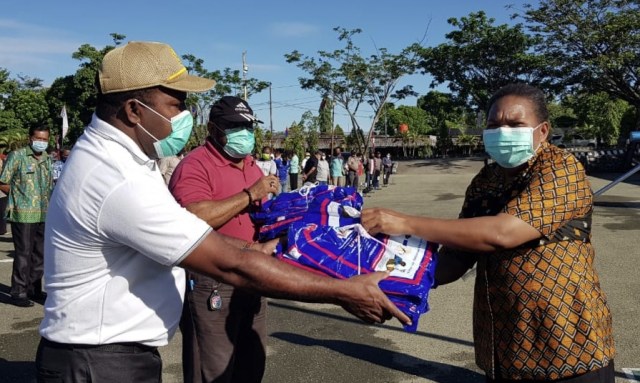 Sekretaris Daaerah Kabupaten Jayapura, Hana Hikoyabi menyerahkan kelambu malaria kepada Kepala Dinas Pemeberdayaan Masyarakat Kampung (DPMK) Kabupaten Jayapura disela-sela apel pagi.  (BumiPapua.com/Alan Youwe)