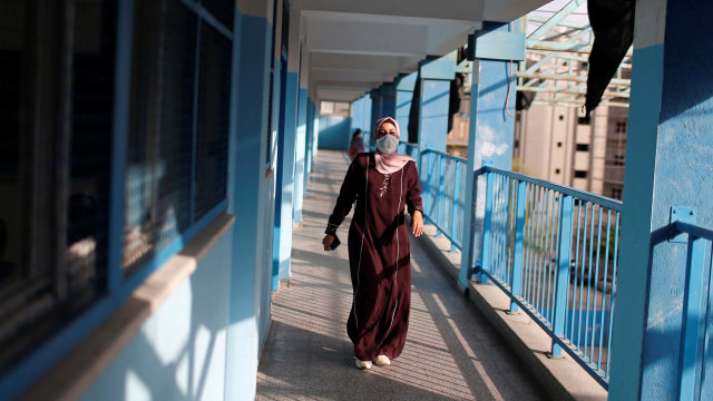 Seorang guru berjalan di sekolah yang didirikan Perserikatan Bangsa-Bangsa (PBB) di Kota Gaza, Palestina. Foto: MOHAMMED SALEM/REUTERS