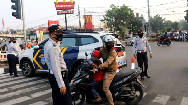 Petugas Suku Dinas Perhubungan Jakarta Timur memberikan sosialisasi terkait protokol kesehatan kepada peserta HBKB di Jalan RA Fadillah, Minggu (9/8). Foto: Sudinhub Jaktim/Handout via ANTARA