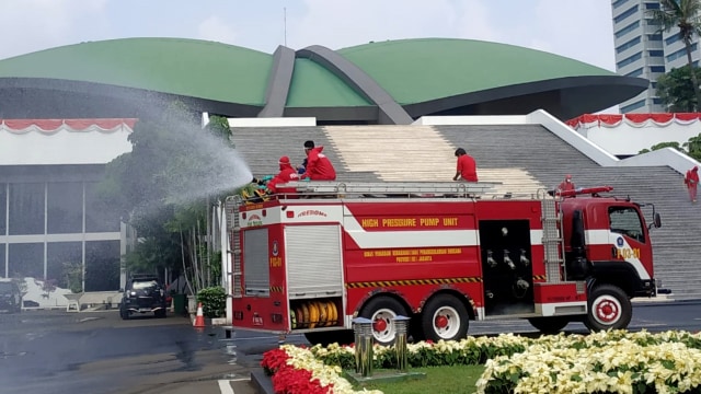 Penyemprotan disinfektan menjelang rapat paripurna terbuka DPR RI tahun 2020 di area komplek gedung MPR/DPR/DPD RI, Senayan, Jakarta Pusat, Minggu (9/8). Foto: Damkar DKI