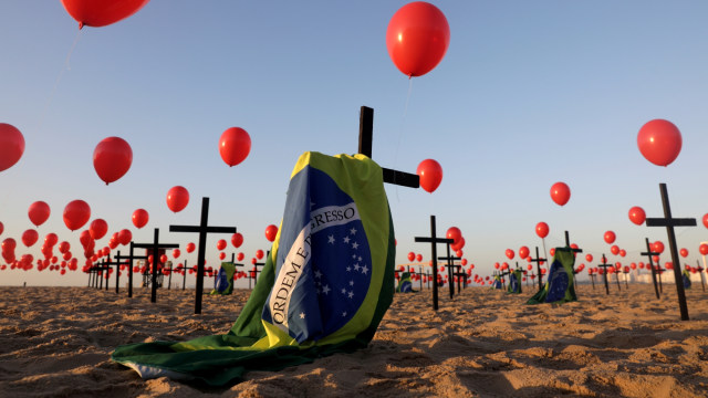 Sejumlah salib dan balon peringatan seratus ribu korban virus corona di Brasil, di pantai Copacabana di Rio de Janeiro, Brasil, (8/8). Foto: Ricardo Moraes/REUTERS 