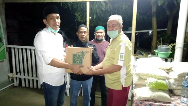 Ketua DPC Partai Kebangkitan Bangsa (PKB) Kabupaten Minahasa Utara (Minut), Sarhan Antili (baju putih) saat memberikan bantuan corona dari Cak Imin kepada warga yang terdampak corona