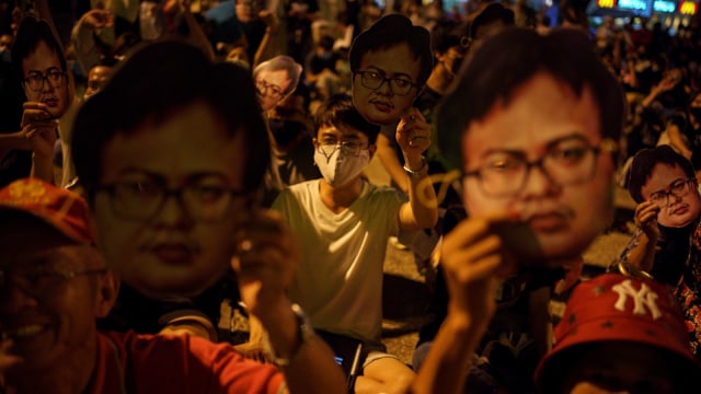 Sejumlah pengunjuk rasa mengankat topeng dengan wajah pengacara HAM Anon Nampa saat melakukan demonstrasi di Chiang Mai, Thailand, Minggu (9.8). Foto: Athit Perawongmetha/REUTERS