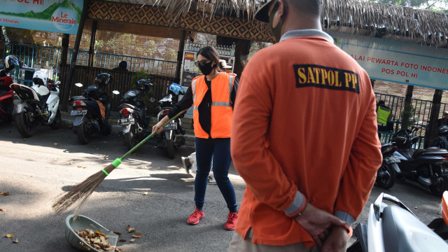 Pelanggar protokol kesehatan mendapatkan sanksi kerja sosial menyapu jalan di kawasan Bundaran HI, Jakarta, Minggu (26/7/2020).  Foto: Indrianto Eko Suwarso/ANTARA FOTO