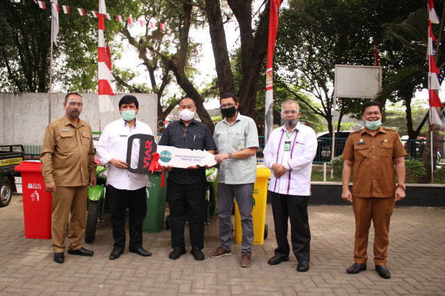 Kepala Dinas Lingkungan Hidup Sumut Binsar Situmorang menyerahkan secara simbolis bantuan becak. Foto: Istimewa