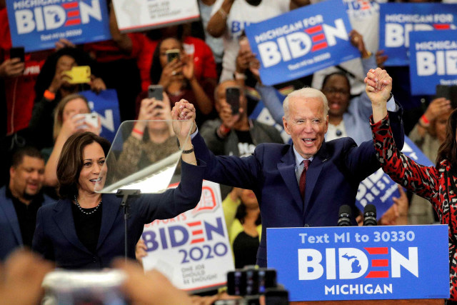 Kandidat presiden AS dari Partai DemokratJoe Biden dan Senator AS Kamala Harris (kiri) bergandengan tangan saat kampanye di Detroit, Michigan, AS, (9/3/2020). Foto: Brendan McDermid/Reuters