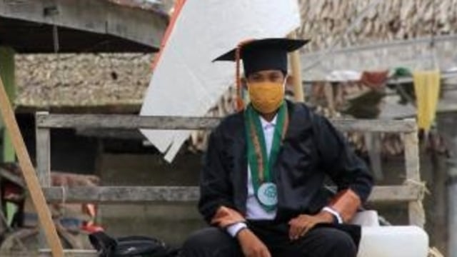 Kamarul (23), wisudawan yang berfoto di tengah lokasi banjir di Masamba. 
 Foto: Instagram/@luung.-