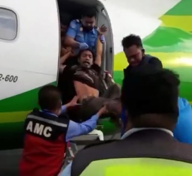 Seorang pria yang diduga mengalami gangguan jiwa tiba-tiba ditarik dari dalam pesawat di Bandara Internasional Radin Inten II Lampung, Rabu (12/8) | Foto: Istimewa