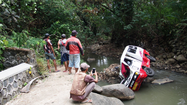 Sejumlah warga melihat kondisi angkot yang terjun ke jurang sedalam 30 meter di Kabupaten Kuningan. (Andri Yanto)