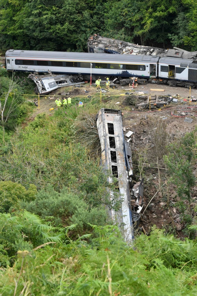 Salah satu gerbong kereta ScotRail terlihat jatuh ke jurang di Stonehaven, Aberdeenshire, Skotlandia, Inggris. Foto: Ben Birchall/Reuters