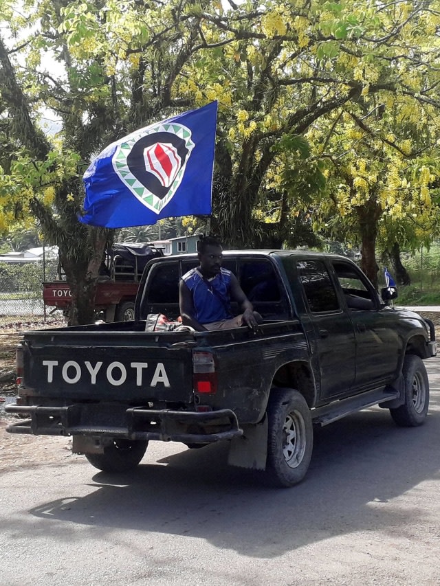 Sebuah kendaraan yang mengibarkan bendera Bougainville lewat saat referendum kemerdekaan yang tidak mengikat di Arawa, di pulau Bougainville, Papua Nugini. Foto: REUTERS/Melvin Levongo