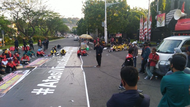 Suasana demonstran saat berorasi dan membentangkan spanduk 30 meter di depan kompleks Gubernuran, Semarang. Foto:  Afiati Tsalitsati/Kumparan