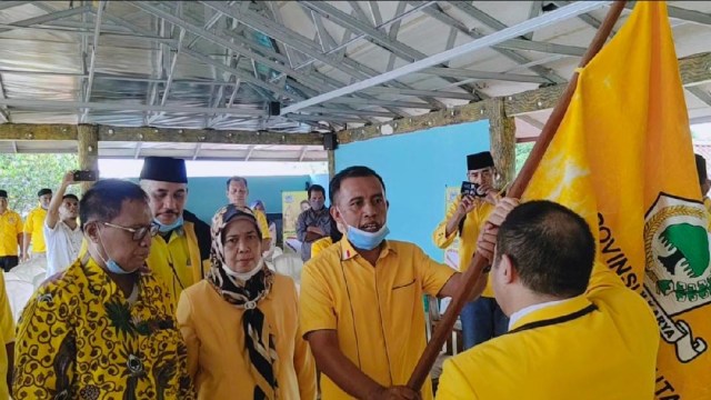 Sekretaris DPD Provinsi Maluku Utara, Arifin Djafar menyerahkan panji Partai Golkar ke Ahmad Zakir Mando sebagai Ketua DPD Halbar terpilih. Foto: Zulfikar Saman/cermat