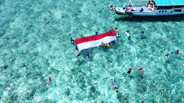 Bendera merah putih dengan panjang 10 meter, lebar 3 meter saat dibentangkan di permukaan laut di perairan Pulau Babi, Kabupaten Sikka. Foto : Dokumentasi MDC. 