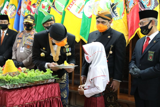 Gubernur Jawa Tengah, Ganjar Pranowo, melangsungkan sesi potong tumpeng di hari jadi Jawa Tengah yang ke-70. Foto: Dok. Pemerintah Provinsi Jawa Tengah