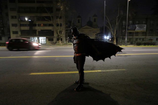 Aksi Batman saat membagikan makanan kepada tunawisma di jalanan selama pandemi Corona di Santiago, Chile. Foto: Ivan Alvarado/Reuters