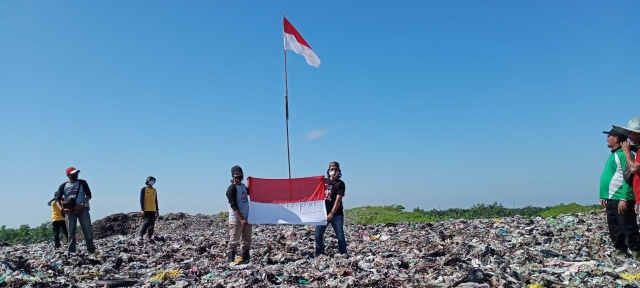 Pengibaran bendera merah putih di atas bukit sampah di TPA Batulayang Pontianak. Foto: Dok Hi!Pontianak