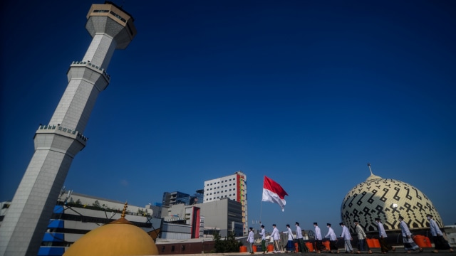Sejumlah pengurus Dewan Kemakmuran Masjid (DKM) mengarak bendera Merah Putih usai mengikuti upacara peringatan kemerdekaan Republik Indonesia di atap Masjid Raya Bandung, Jawa Barat, Senin (17/8).  Foto: Raisan Al Farisi/ ANTARA FOTO