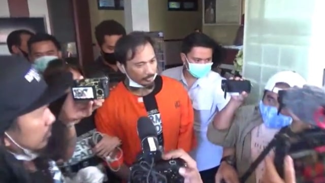 Jerinx memakai baju tahanan dan diborgol usai menjalani pemeriksaan di Polda Bali. Foto: Denita BR Matondang/kumparan