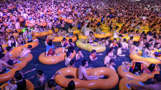 Sejumlah pengunjung menonton pertunjukan di kolam renang di Wuhan, Hubei, China. Foto ini diambil pada 15 Agustus 2020. Foto: STR/AFP