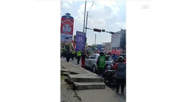 Para pengendara berhenti sejenak di lampu merah untuk memberi hormat kepada bendera. Sumber Foto: Instagram.com/@dramaojol.id