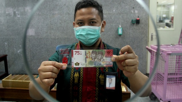 Petugas memperlihatkan uang baru pecahan Rp75.000 di Bank Indonesia, Padang, Sumatera Barat, Selasa (18/8). Foto: Muhammad Arif Pribadi/ANTARA FOTO