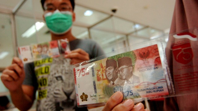 Sejumlah warga menunjukkan uang baru pecahan Rp75.000 di Kantor Perwakilan (Kpw) Bank Indonesia (BI), Tegal, Jawa Tengah, Selasa (18/8). Foto: Oky Lukmansyah/ANTARA FOTO
