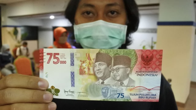 Warga menunjukkan uang baru pecahan Rp75.000 yang merupakan Uang Peringatan Kemerdekaan 75 Tahun Republik Indonesia di Kantor Perwakilan Bank Indonesia Jember, Jawa Timur, Rabu (19/8). Foto: Seno/ANTARA FOTO