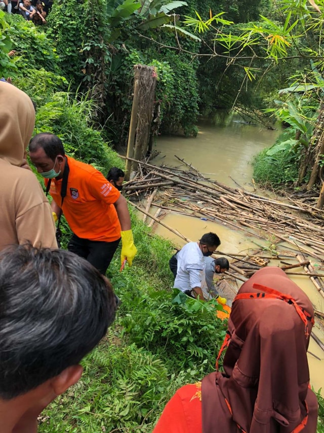 Polisi mengevakuasi mayat pria tanpa identitas di dalam karung di di Sungai Merah, Desa Sei Merah, Tanjung Morawa, Deli Serdang, Sumatera Utara, Rabu (19/8). Foto: Dok. Istimewa