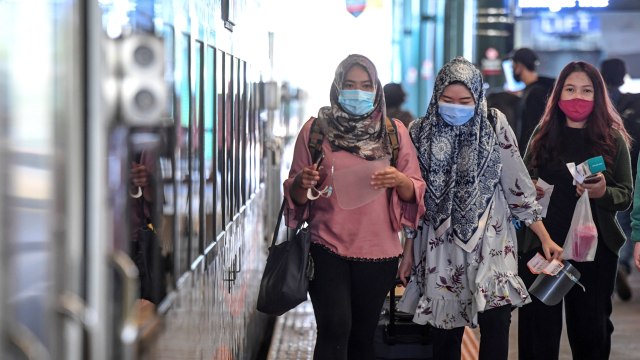 Penumpang mengenakan masker saat bersiap menaiki Kereta Api Turangga tujuan Surabaya Gubeng di Stasiun Gambir, Jakarta, Kamis (20/8). Foto: Hafidz Mubarak A/ANTARA FOTO