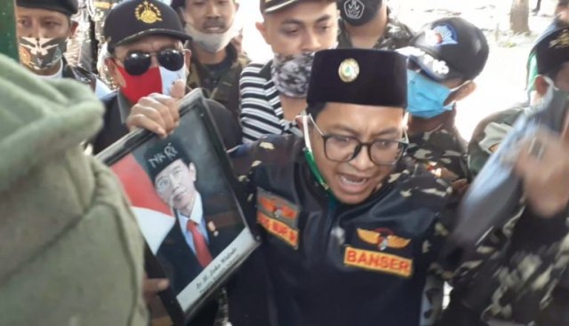 MINTA DITUTUP: Ketua GP. Ansor Bangil, Saad Muafi menunjukkan foto presiden milik yayasan yang dicoret-coret. Foto: Romadoni.