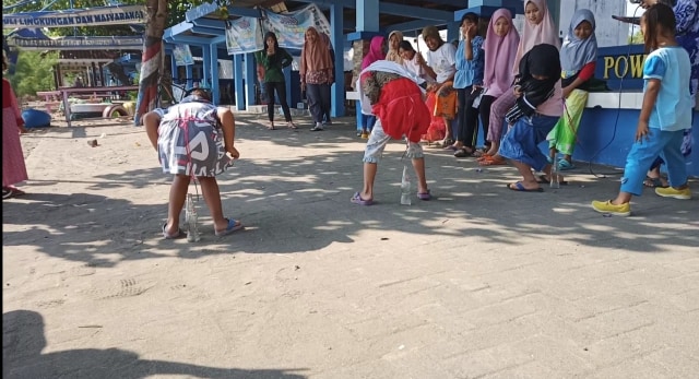 Lomba masukkan paku ke botol