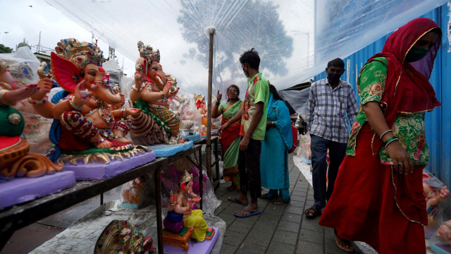 Para pemuja membeli berhala Dewa Hindu Ganesh pada hari pertama festival Ganesh Chaturthi di Mumbai, India, Sabtu (22/8/2020). Foto: HEMANSHI KAMANI/REUTERS