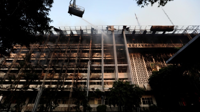 Petugas pemadam kebakaran berusaha mendinginkan kebakaran di kantor Kejaksaan Agung, Jakarta. Foto: Willy Kurniawan/REUTERS
