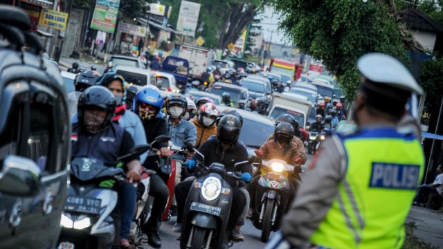 Polisi mengatur kendaraan dari arah Garut, Tasikmalaya dan Sumedang menuju Kota Bandung terjadi di Cinunuk, Kabupaten Bandung, Jawa Barat, Minggu (23/8). Foto: Raisan Al Farisi/ANTARA FOTO
