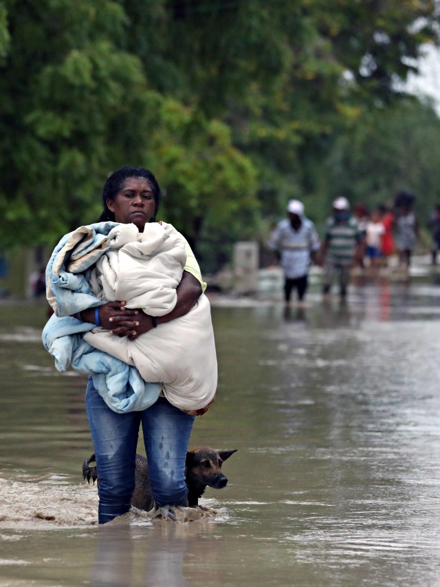 Warga mengungsi saat banjir yang disebabkan oleh melintasnya Badai Laura di Azua, Republik Dominika. Foto: Ricardo Rojas/Reuters