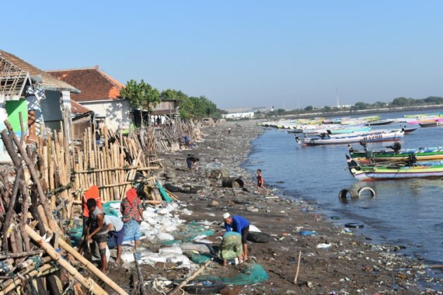 ABRASI: Warga swadaya membenahi penahan yang rusak usai diterjang ombak, Jumat (21/08/2020). Abrasi air laut membuat sebagian rumah terancam hantaman ombak. Foto: Romadoni.