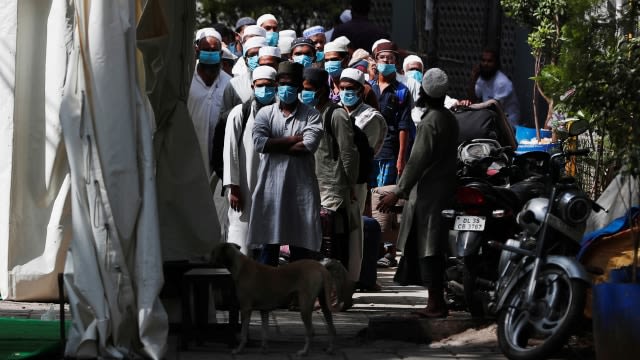 Sejumlah pria menggunakan masker bersiap dibawa ke fasilitas karantina antisipasi virus corona di daerah Nizamuddin, New Delhi, India. Foto: REUTERS / Danish Siddiqui