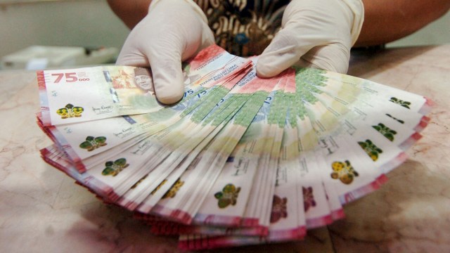Petugas menunjukkan uang baru pecahan Rp75.000 di Kantor Perwakilan (Kpw) Bank Indonesia (BI), Tegal, Jawa Tengah, Selasa (18/8). Foto: Oky Lukmansyah/ANTARA FOTO