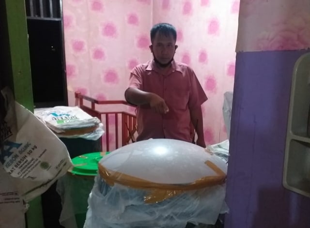 Pejabat sementara Kasat Narkoba Polres Jayawijaya, Iptu Frets Lamahan saat memperlihatkan sejumlah barang bukti miras lokal. (Dok Polda Papua) 