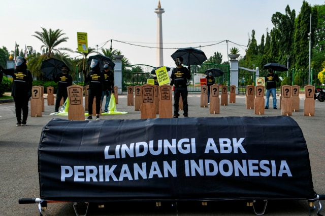 Aktivis buruh memasang nisan dan membawa keranda mayat saat melakukan aksi damai di depan Istana Merdeka, Jakarta, Kamis (27/8). Foto: M Risyal Hidayat/Antara Foto