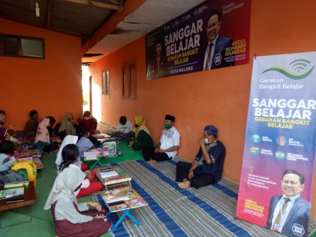 Bendahara Fraksi PKB DPRD Kota Malang Abd Wahid saat mengajak siswa belajar menggunakan WiFi gratis di Kelurahan Kedungkandang, Kota Malang, Sabtu (29/8). Foto: jaf