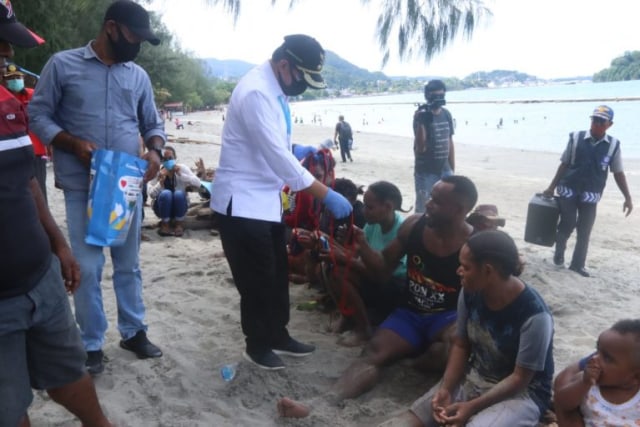 Wakil Wali Kota, Rustan Saru saat membagikan masker kepada pengunjung di lokasi wisata Pantai Hamadi Kota Jayapura. (Dok Humas Pemkot Jayapura)
