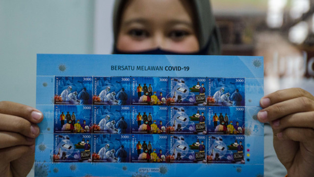Pegawai menunjukkan Full Sheet Perangko edisi Bersatu Melawan COVID-19 di Kantor Pos Asia Bandung, Jawa Barat, Senin (31/8/2020). Foto: NOVRIAN ARBI/ANTARA FOTO