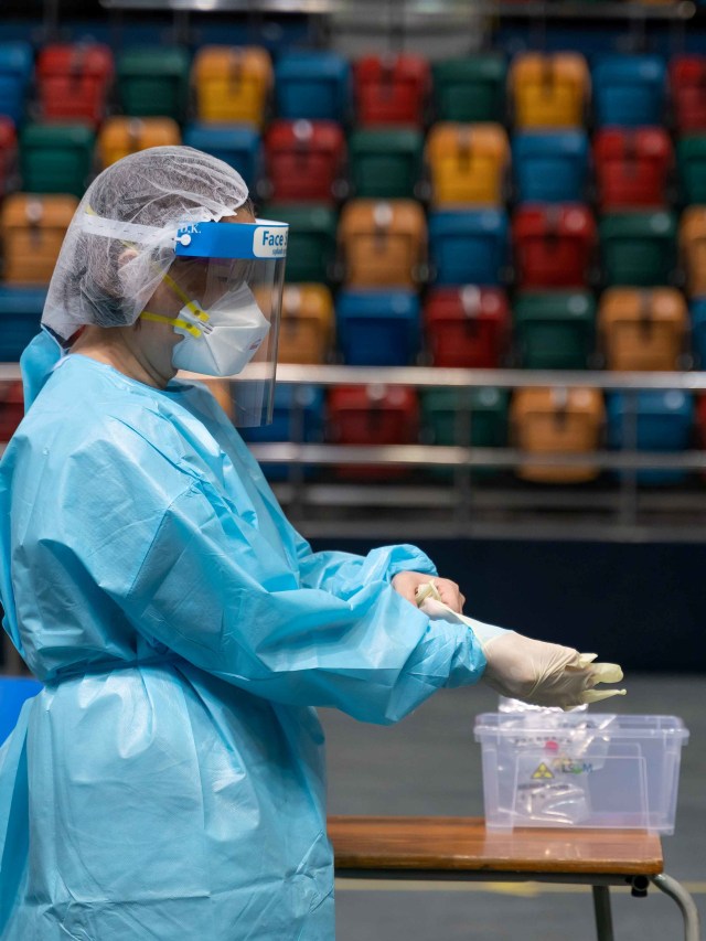 Salah satu petugas menyiapkan alat untuk mengambik sampel swab di pusat pengujian komunitas untuk penyakit COVID-19 di Hong Kong. Foto: Anthony Kwan/REUTERS