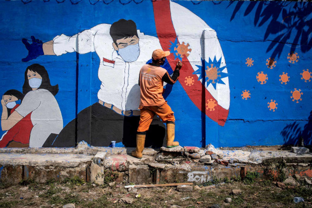 Petugas PPSU Bukit Duri menyelesaikan pembuatan mural yang berisi pesan waspada penyebaran virus Corona di kawasan Tebet, Jakarta. Foto: Aprillio Akbar/Antara Foto